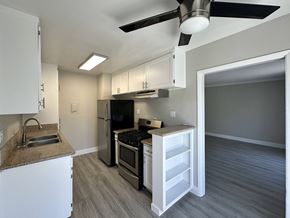 West Hollywood apartment for rent - A kitchen with a black fridge and stove top oven.