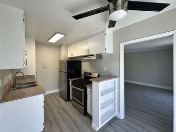 West Hollywood apartment for rent - A kitchen with a black fridge and stove top oven.