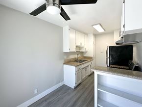 West Hollywood apartment for rent - A kitchen with a black fridge and a fan on the ceiling.
