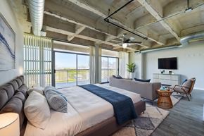 Houston apartment for rent - A bedroom with a large bed and a balcony overlooking the city.
