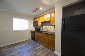 Houston apartment for rent - A kitchen with wooden cabinets and a black refrigerator.