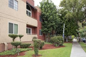 Glendale apartment for rent - Apartment building with a red brick facade and a green lawn in front.
