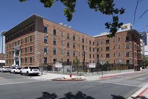 Reno apartment for rent - A large brick building with a black fence in front of it.