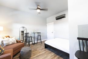 Reno apartment for rent - A bedroom with a bed, a couch, and a ceiling fan.