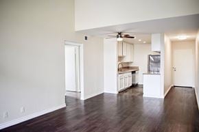 Glendale apartment for rent - A kitchen with white cabinets and a refrigerator is visible from the living room.