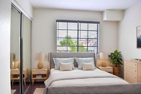 Glendale apartment for rent - A bedroom with a large bed and a window with blinds.