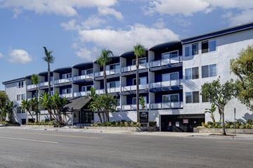 Torrance apartment for rent - A modern apartment building with balconies and palm trees in front.