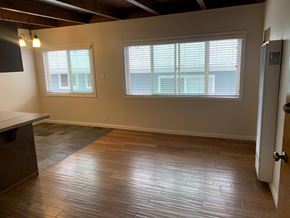 Hermosa Beach apartment for rent - A room with wooden floors and a large window.