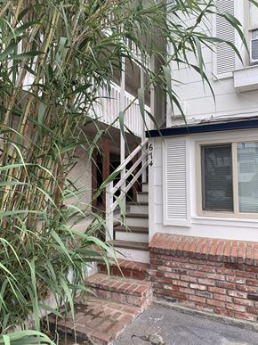 Hermosa Beach apartment for rent - A white house with a black roof and a brick base.