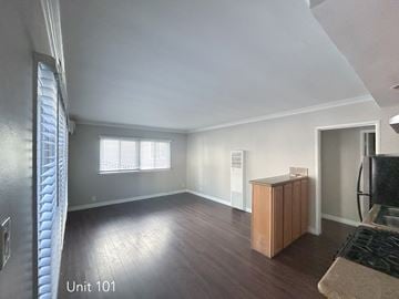 Hollywood apartment for rent - A living room with wooden floors and a window with blinds.