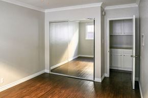 Hollywood apartment for rent - a bedroom with a mirrored closet door and a hard wood floor