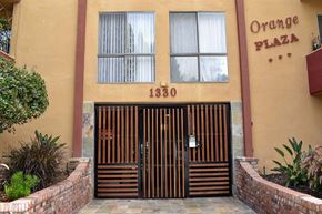 Los Angeles apartment for rent - the entrance to an orange plaza building with a gate