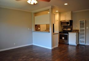 Sherman Oaks apartment for rent - View into dining and kitchen with wood look flooring, tile backsplash, stainless appliances, and white cabinets