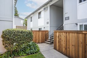 Tracy apartment for rent - the back yard of a white apartment building with a wooden fence