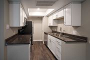 Tyler apartment for rent - View of kitchen with whit cabinets, stainless appliances, dark counters, and wood look floorin