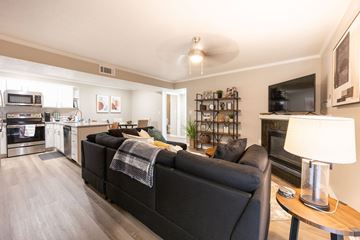 Tyler apartment for rent - A black couch with a blanket on it sits in a living room.