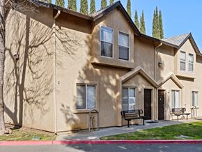 Chico apartment for rent - A beige building with a black door and windows.
