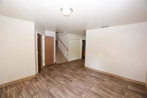 Chico apartment for rent - Living room view with wood look flooring, stairs leading to upstairs bedrooms, and hall way