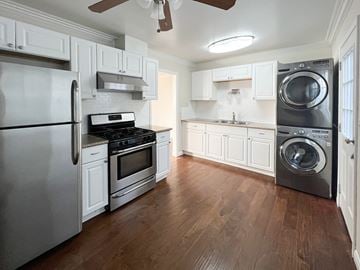 Hermosa Beach apartment for rent - a kitchen with stainless steel appliances and white cabinets and a washer and dryer