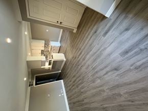 Sherman Oaks apartment for rent - View into living area, dining area, and kitchen. Has recessed lighting, wood like flooring, and white cabinets.
