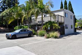 Santa Barbara apartment for rent - A blue car is parked in front of a two-story building.