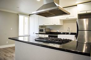 Santa Barbara apartment for rent - A modern kitchen with a stainless steel refrigerator and a black countertop.