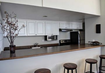 Torrance apartment for rent - A kitchen with white cabinets and a brown counter.