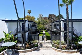 Torrance apartment for rent - View of pool seating area and sidewalk leading in between buildings