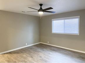 Manteca apartment for rent - living room with wood look flooring, ceiling fan, and well lit window