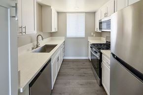 Lompoc apartment for rent - A modern kitchen with stainless steel appliances and white cabinets.