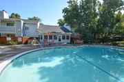 Citrus Heights apartment for rent - View of gated community pool with seating under umbrellas, exterior building and office in background