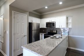 Bossier City apartment for rent - View of open kitchen area with wood look flooring, granite counters, tile backsplash, stainless appliances and recessed lighting.