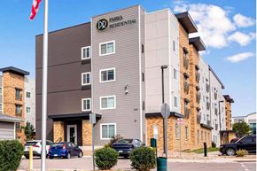 Centennial apartment for rent - a building with a flag and cars parked in front of it at Parks Residential - Denver, Centennial, CO 80111