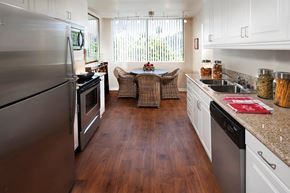 Marina Del Rey apartment for rent - A kitchen with a refrigerator on the left and a dining table in the middle.