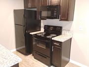 Turlock apartment for rent - a kitchen with black appliances and a refrigerator at Park Place, Turlock, California