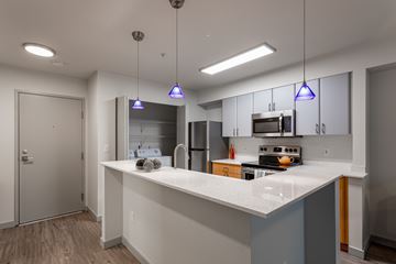 Seattle apartment for rent - A kitchen with a white countertop and a stainless steel refrigerator.