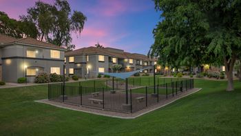 A fenced in yard with apartments in the background