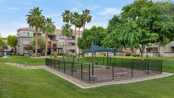 A fenced in area with a pavilion in the middle of a park