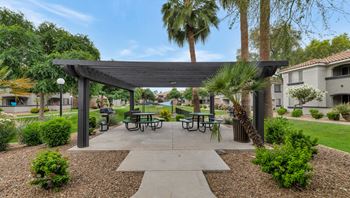 A picnic area with tables and awnings in a courtyard