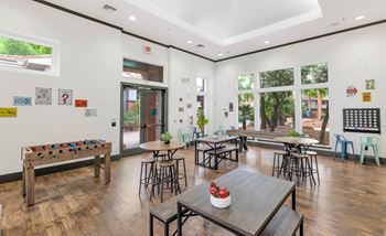 A common room with tables and chairs and a large window