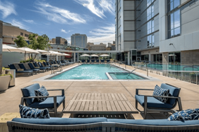 Phoenix apartment for rent - A large outdoor pool area with lounge chairs and umbrellas.