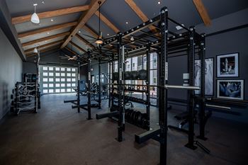 A gym with a variety of equipment including a squat rack, bench, and weights