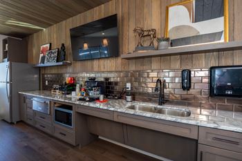 A modern kitchen with a wooden ceiling and a large island with a sink