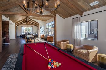 A pool table with a red cloth and a pool cue with a colorful pool ball on it