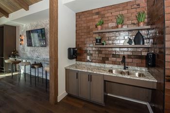 A kitchen with a brick wall and a marble countertop
