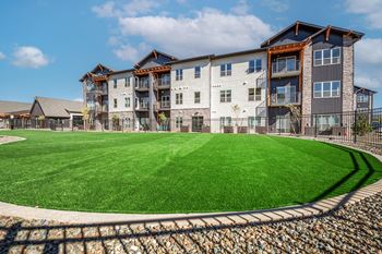 A large grassy area in front of a multi-story building
