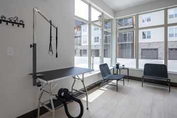 A room with a table, chairs and a vacuum cleaner