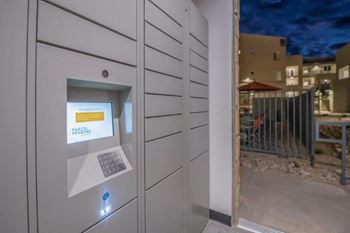 A parking meter in the side of a building at night