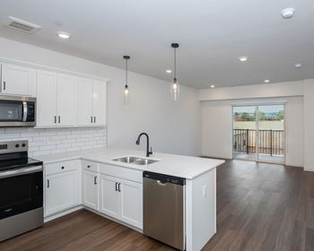 A modern kitchen with white cabinets and stainless steel appliances