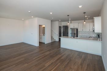 A kitchen with white cabinets and a wooden floor